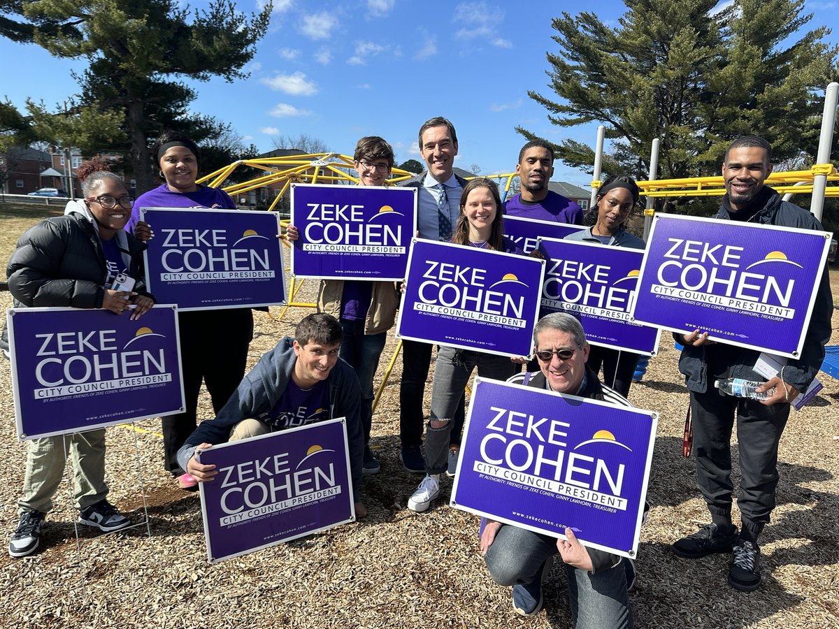 Zeke and the team holding yard signs.
