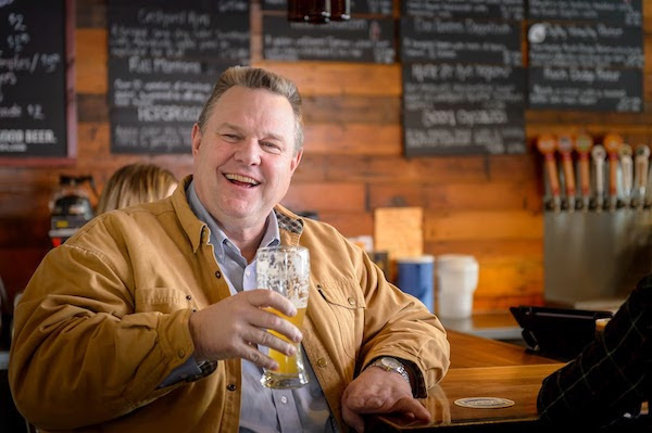 Jon Tester holding a glass of beer