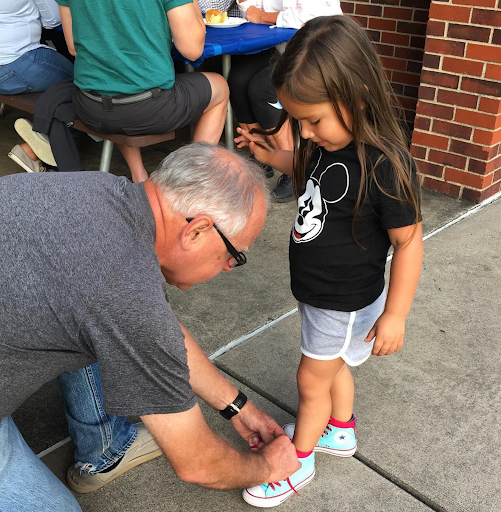 Tim Walz tying girl's shoe 