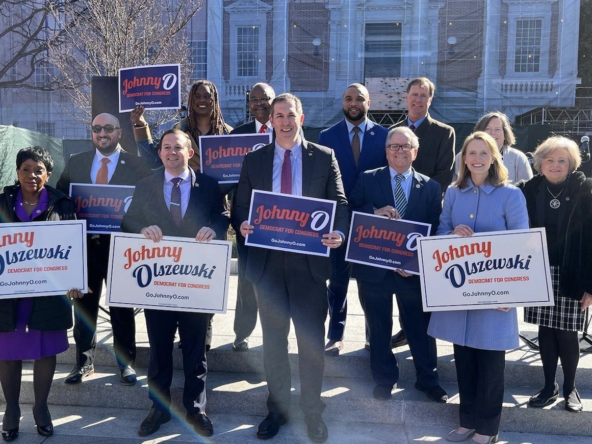 Johnny O holding yard signs with others.