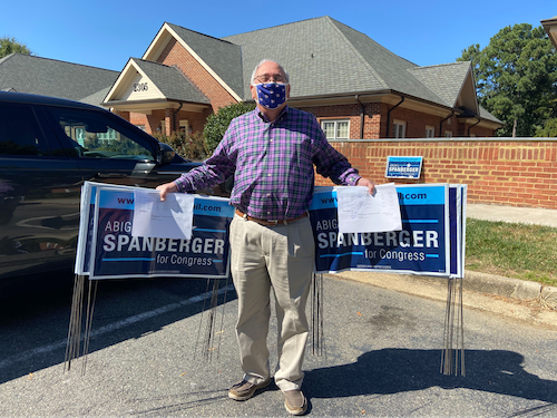 Photo of me posing with some yard signs when distributing to supporters across the district!