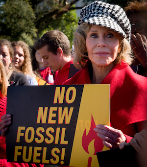 Headshot of Jane Fonda at a protest, holding a sign