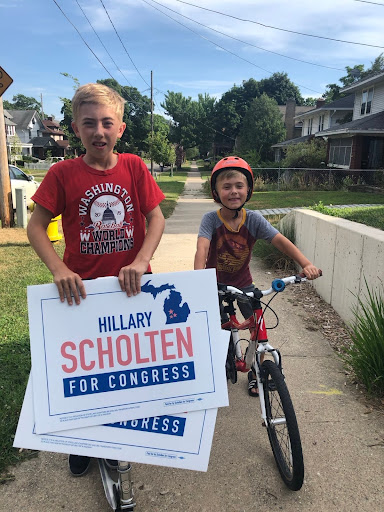 Boys handing out yard signs