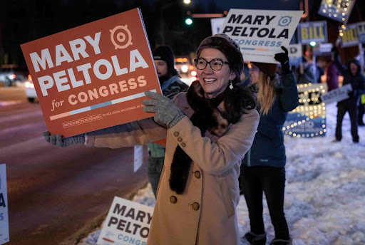 Mary Peltola holding a yard sign