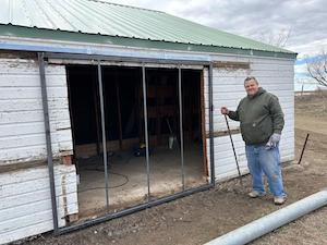 Photo of Jon Tester standing on his farm