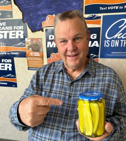 Jon Tester holding a jar of pickles