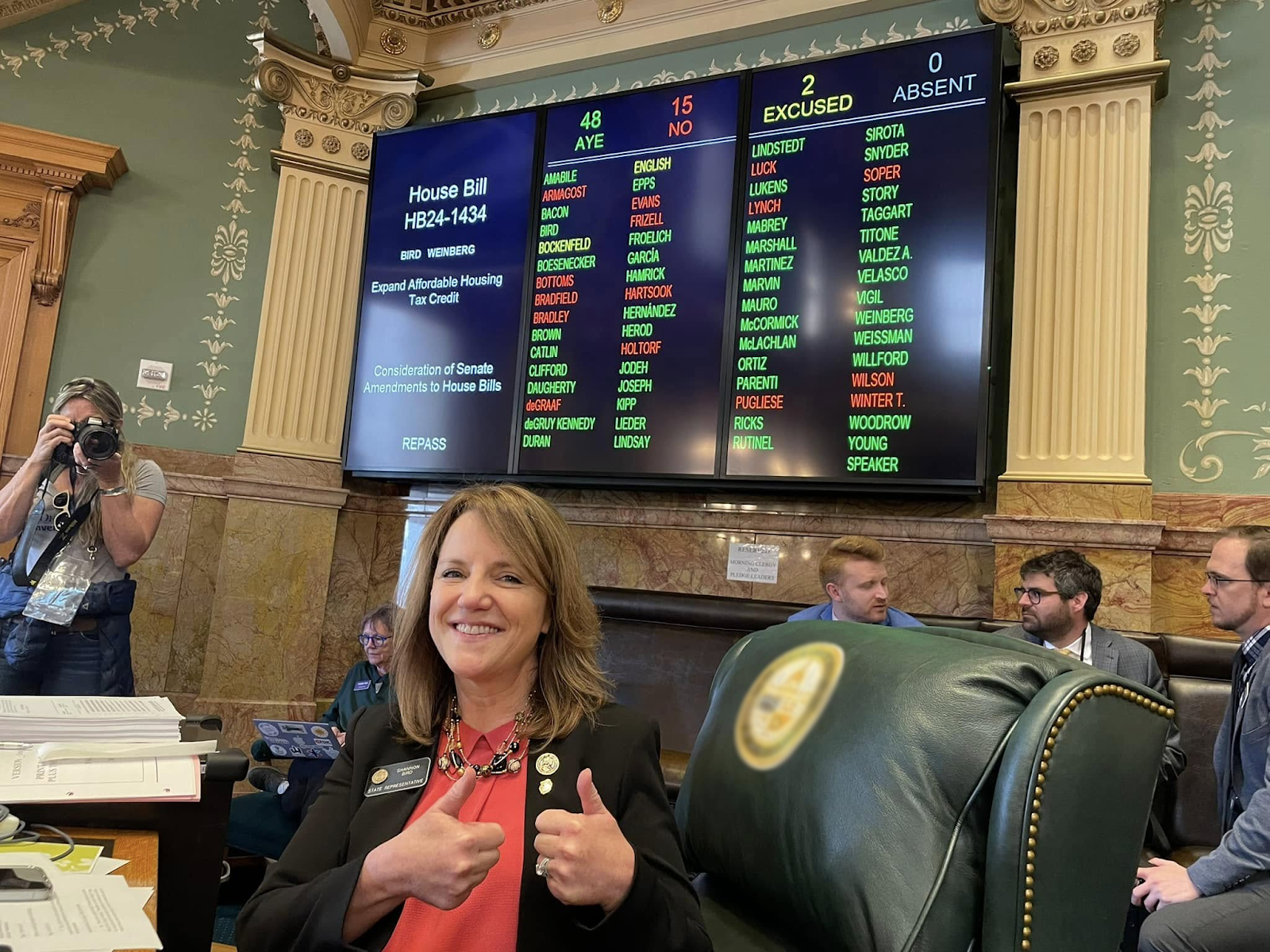 Shannon giving thumbs up in front of State House voting board for expanding the affordable housing tax credit