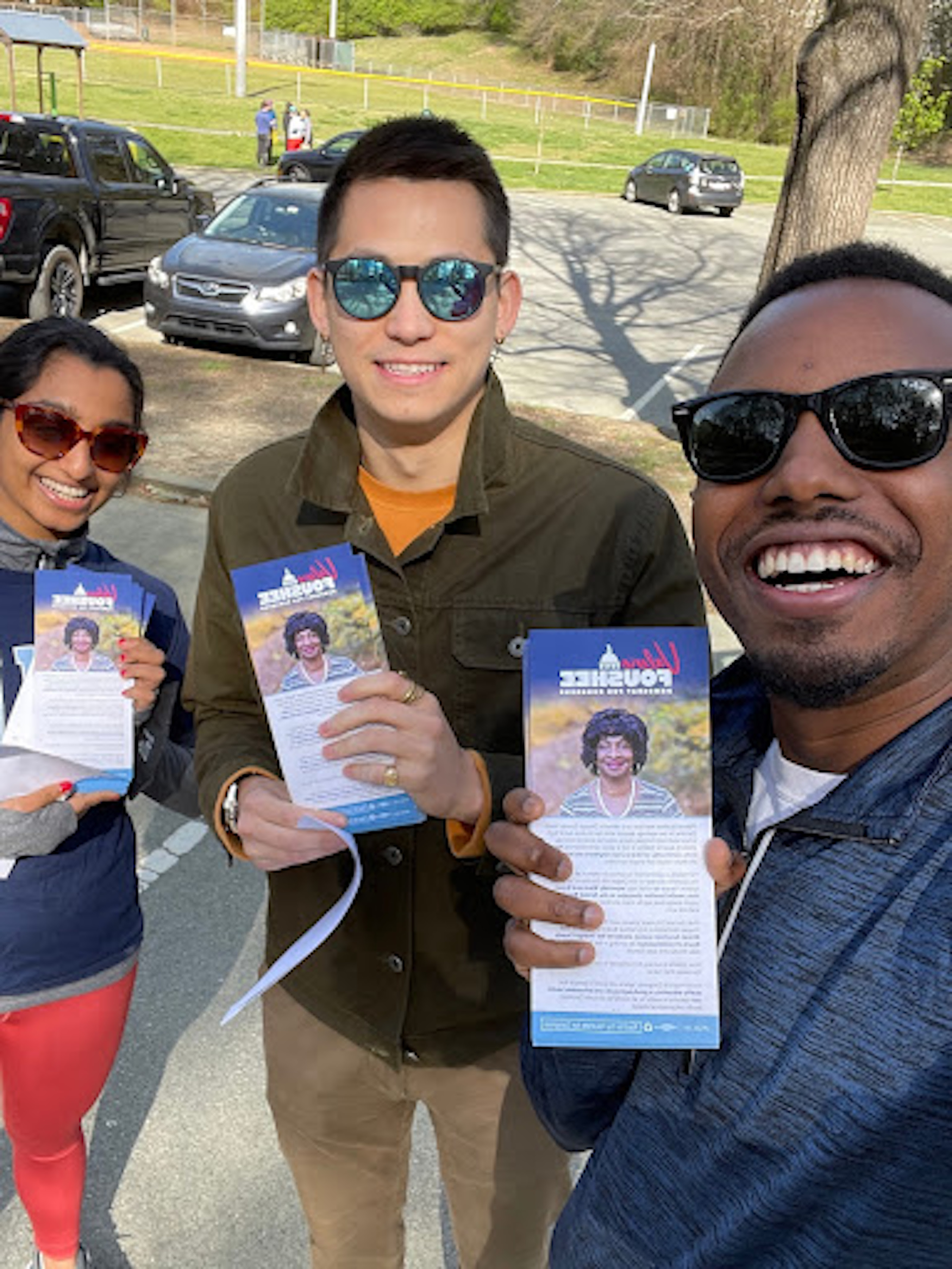 Three canvassers holding up pamphlets and smiling in a selfie